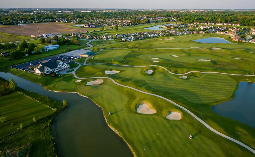 Aerial shot of stone ridge golf course featuring the club house, multiple holes, and a long body of water.